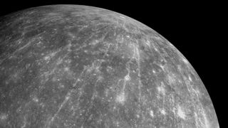 a grey orb streaked with white lines and dotted with white craters
