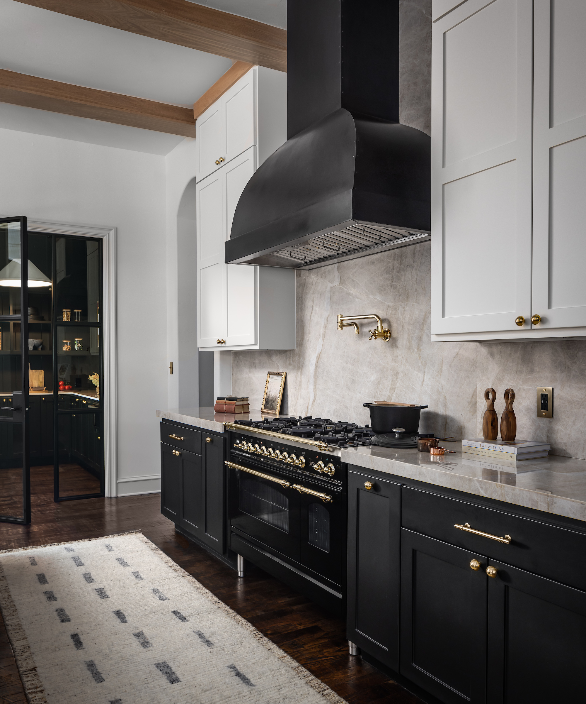 BLACK AND WHITE KITCHEN WITH large cooker hood and rug