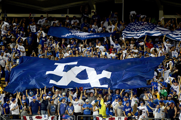 LA Dodgers fans hold signs in the bleachers.