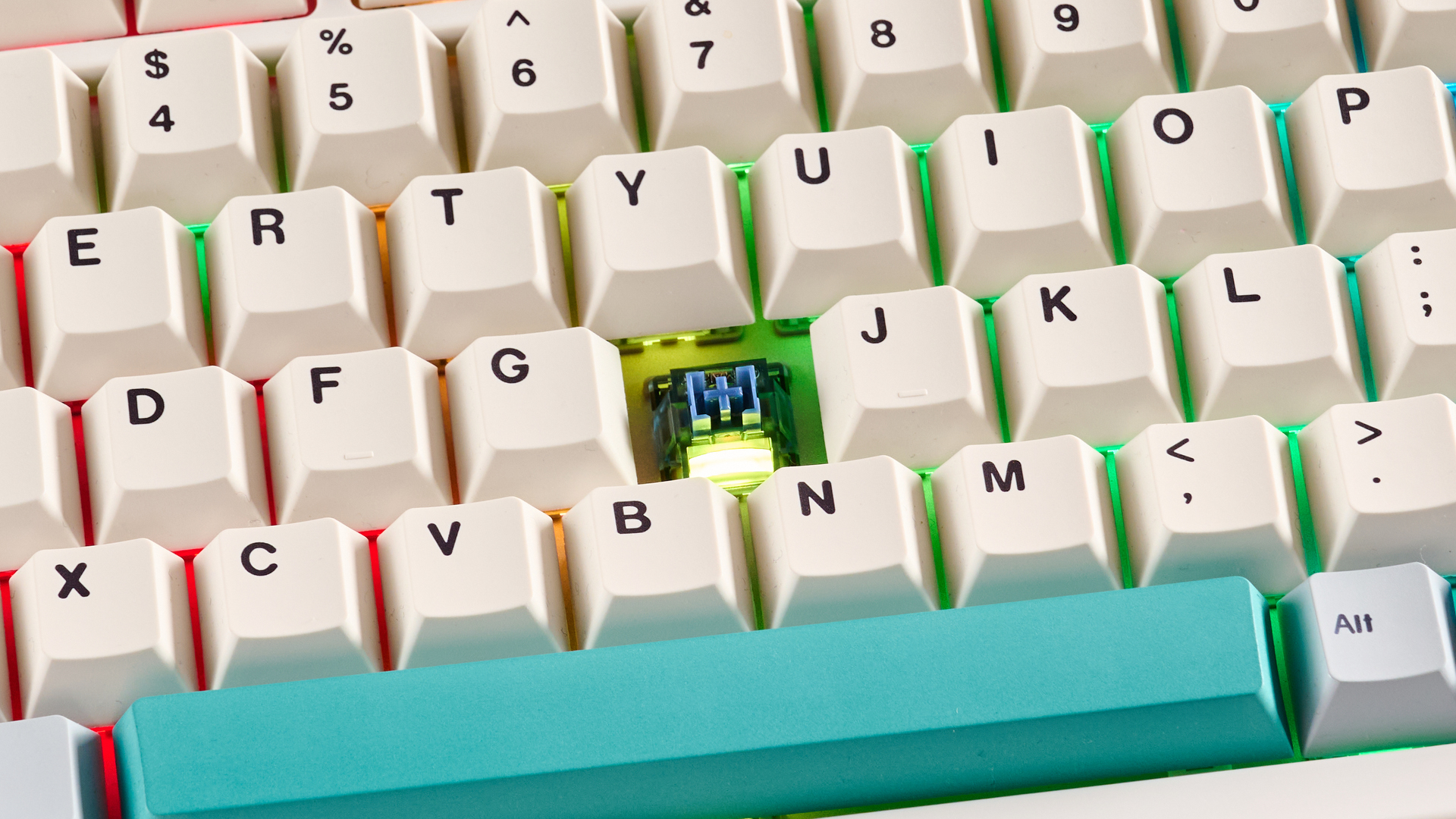 Close-up of keys on Gamakay TK75 V2 with RGB lighting on and one keycap removed, exposing switch beneath