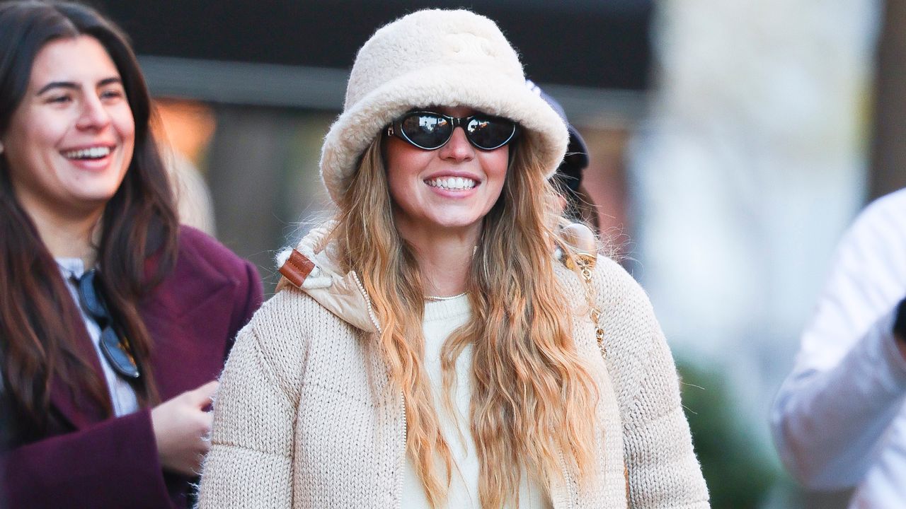 Sydney Sweeney wearing a furry bucket hat and knit puffer in NYC