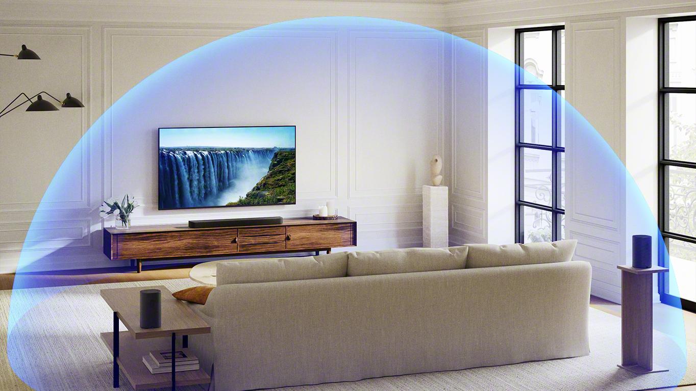 A modern living room with a Sony soundbar and surround speakers, with a blue bubble signifying Dolby Atmos sound