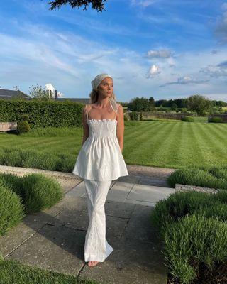 Elsa Hosk wearing a white waistcoat and skirt with a headscarf