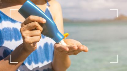 woman applying sunscreen while wearing a blue summer dress, needing to know how to get sunscreen out of clothes