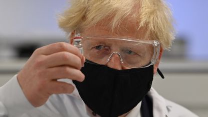 Boris Johnson with a vial of the Oxford-AstraZeneca vaccine