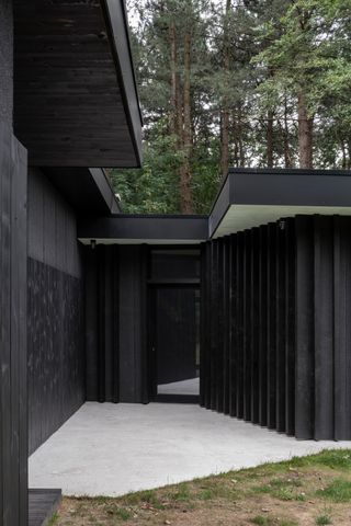House BPB by David Bulckaen is a 1960s bungalow renovation clad in dark timber