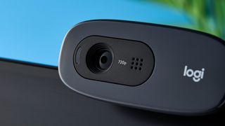 a small, black, oblong-shaped webcam with a universal attachment clip and a logi logo