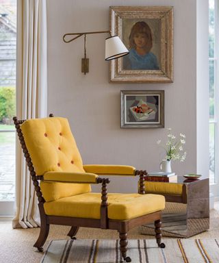 neutral living room corner with a yellow vintage chair and a mirror cube table and vintege art