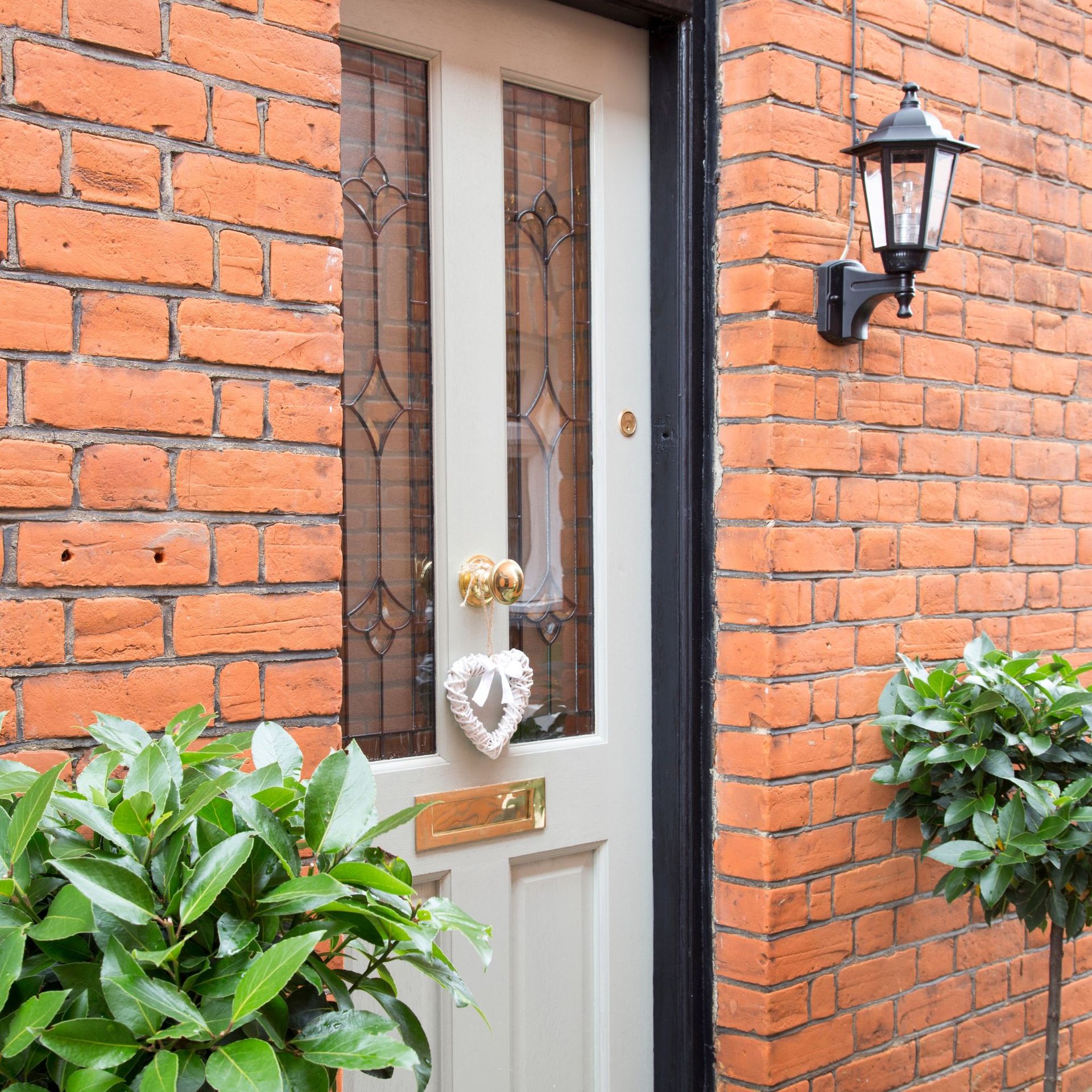 Front door framed by two bay leaf trees