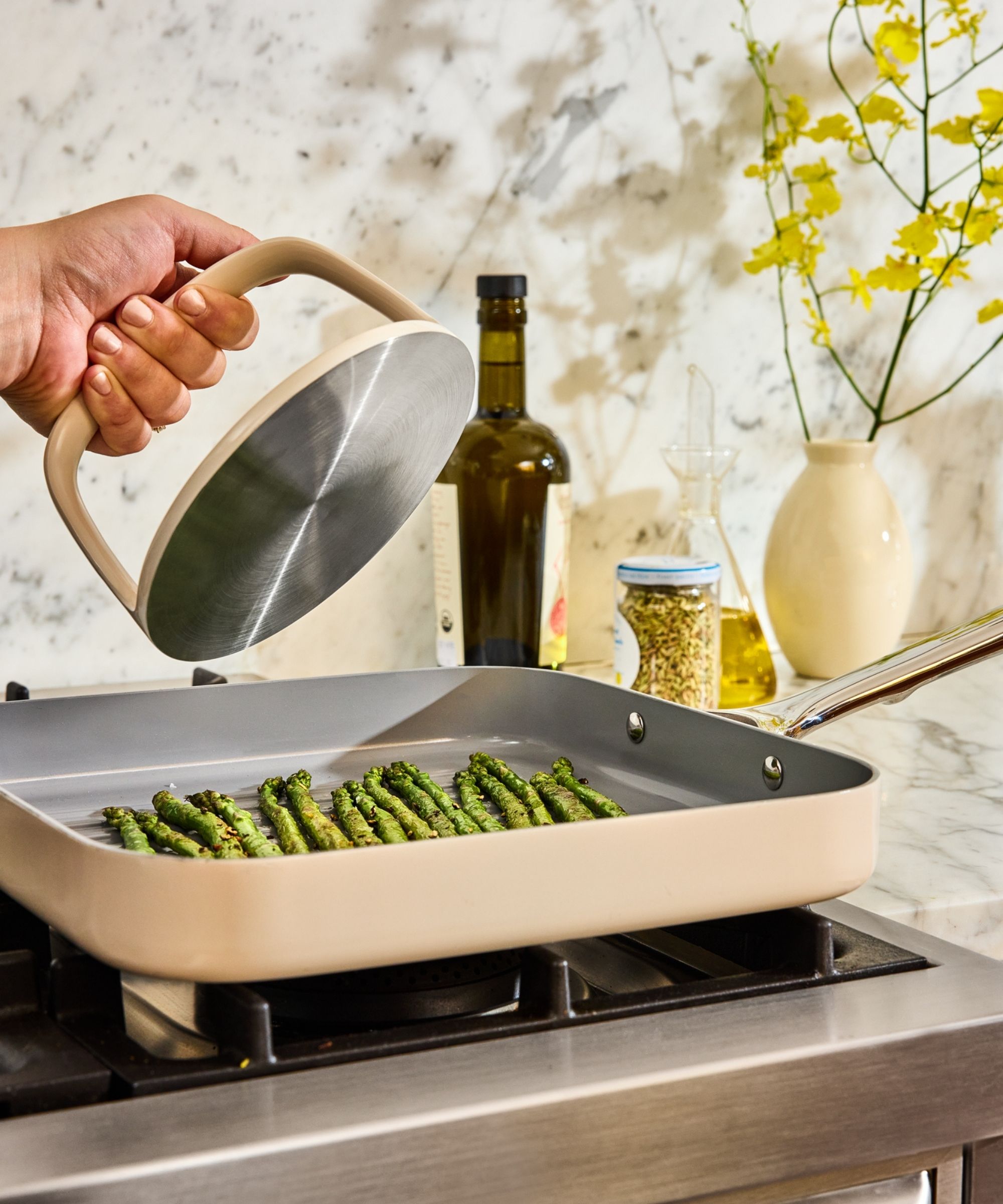 Asparagus in white baking pan with white grill press