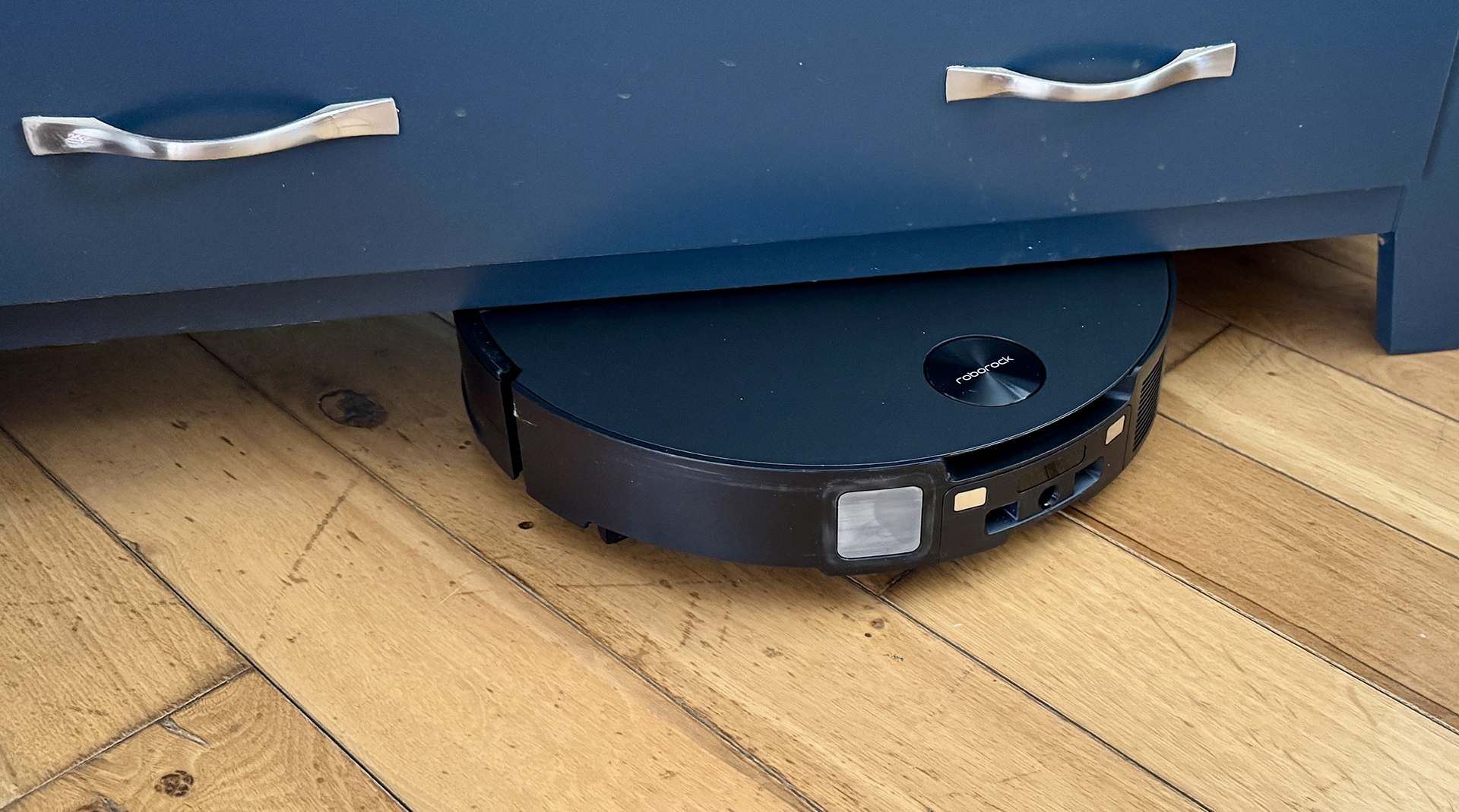 Roborock Saros 10 robot vacuum going under a cabinet