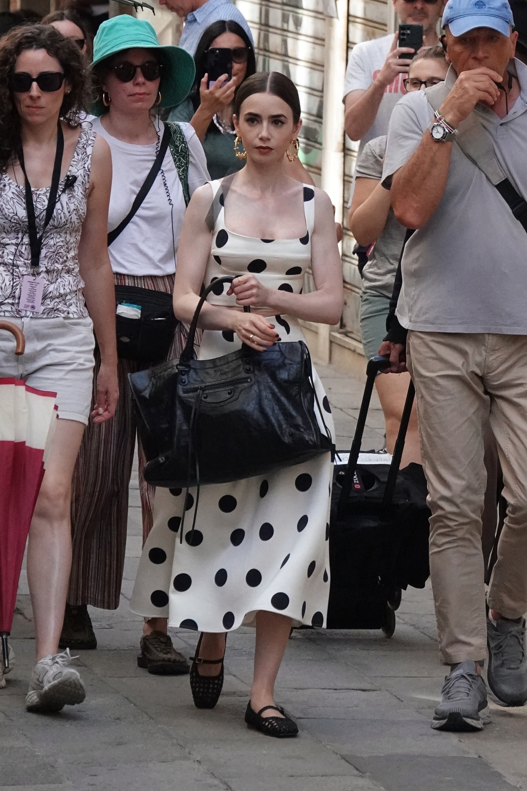 Lily Collins was spotted on the set of Emily In Paris wearing the Balenciaga City Bag