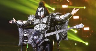 Gene Simmons in full God Of Thunder mode addresses the crows during Kiss's farewell tour, arms outstretched.