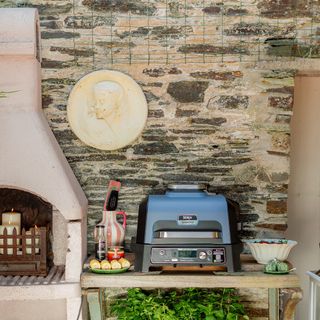 Ninja Woodfire Pro Connect XL and candle display in Anouska Lancaster's walled garden outdoor kitchen area