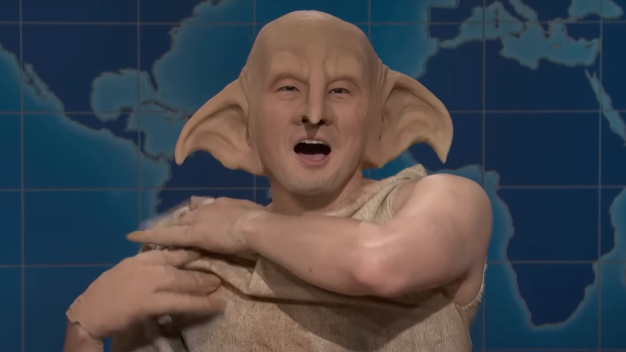 Bowen Yang dressed up as Dobby The House Elf, grabbing his tunic after it came undone.