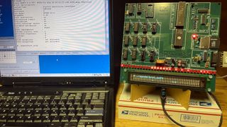 A photo of an Intel 4004 custom circuit board emulating a MIPS R3000 processor, loading the kernal of Debian Linux