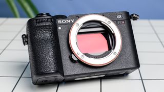 The Sony A7CR on a white table with a blue wall in the background