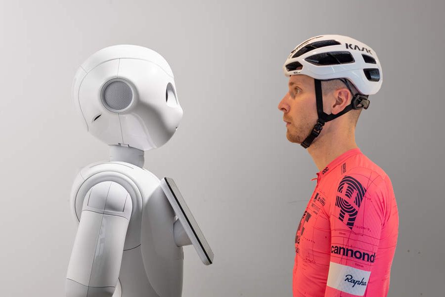 A robot and Josh - in cycling kit - stare each other down