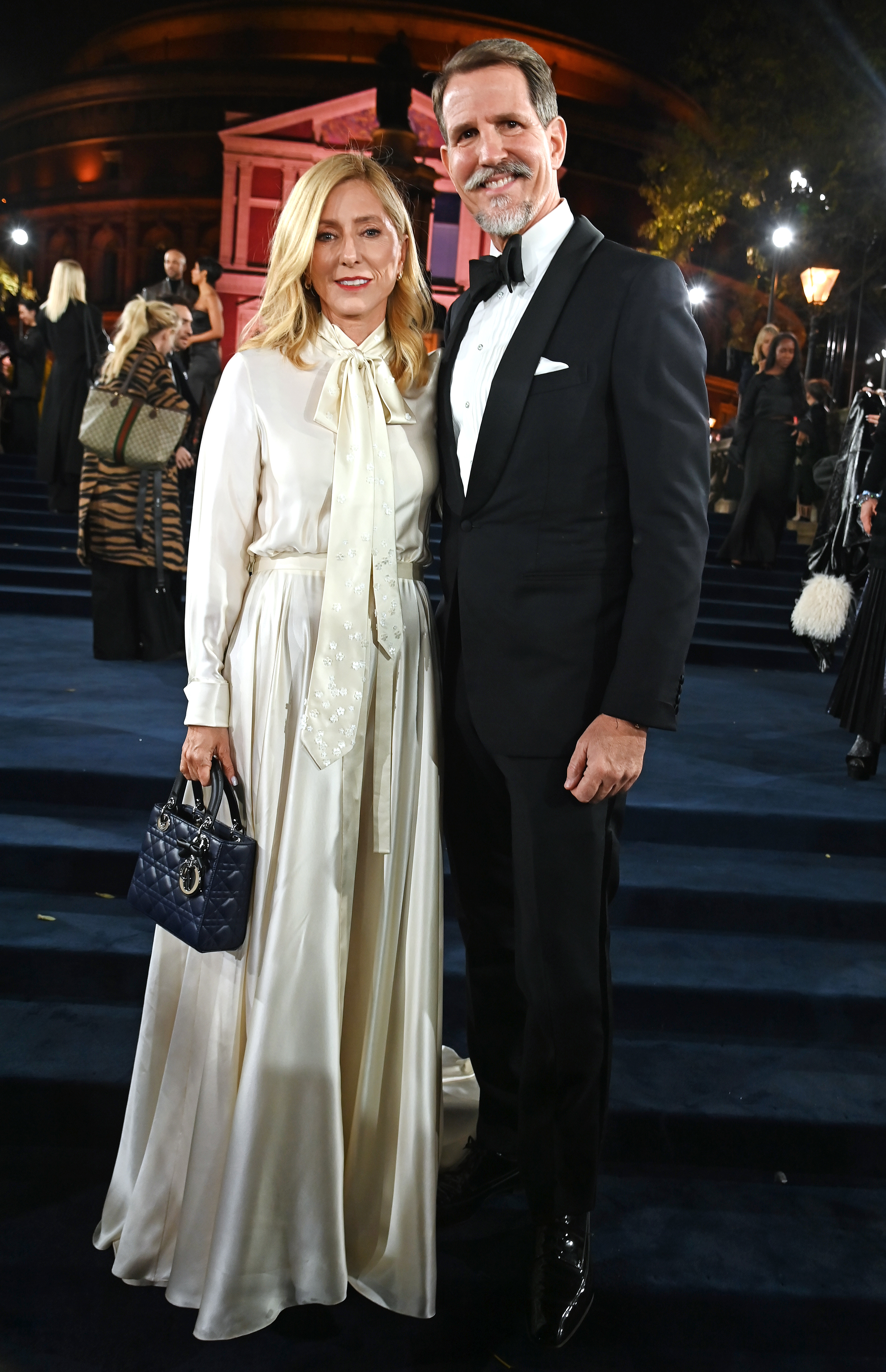 Marie-Chantal, Crown Princess of Greece, wearing a cream blouse and skirt, and Pavlos, Crown Prince of Greece, wearing a tuxedo, attend The Fashion Awards 2025