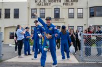Artemis 2 NASA astronaut Reid Wiseman cheers while carrying Rise, the mission mascot. 
