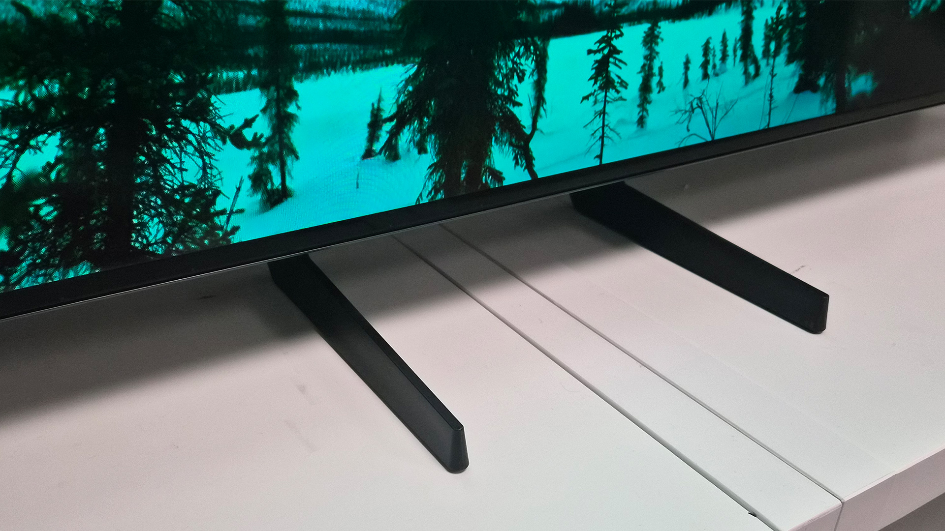 Samsung S85H OLED TV showing bottom of TV with feet in centre position