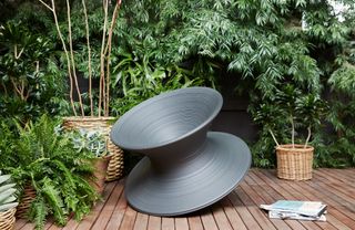 The Magis Spun chair from Herman Miller against a leafy backdrop