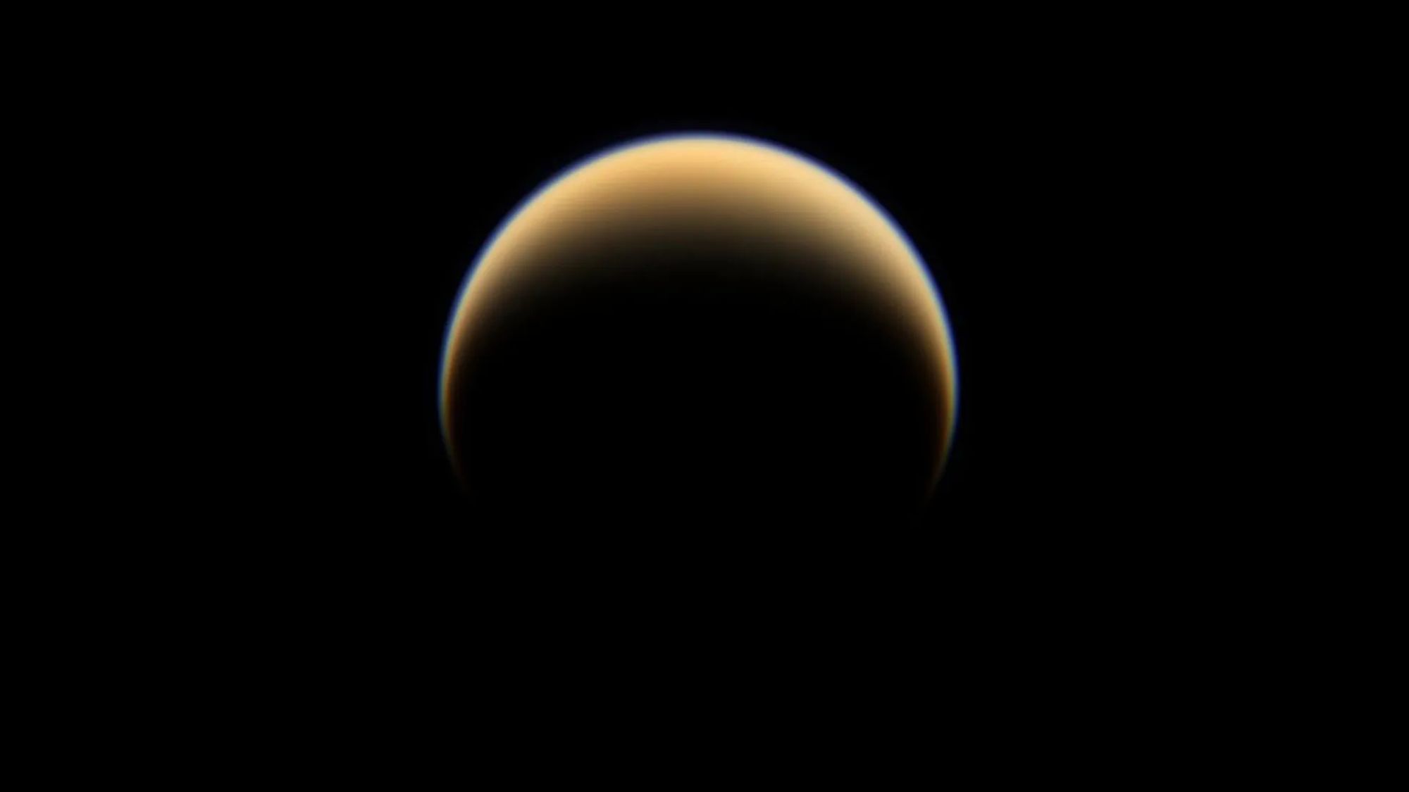 A yellowish crescent pointing downward on a dark background.