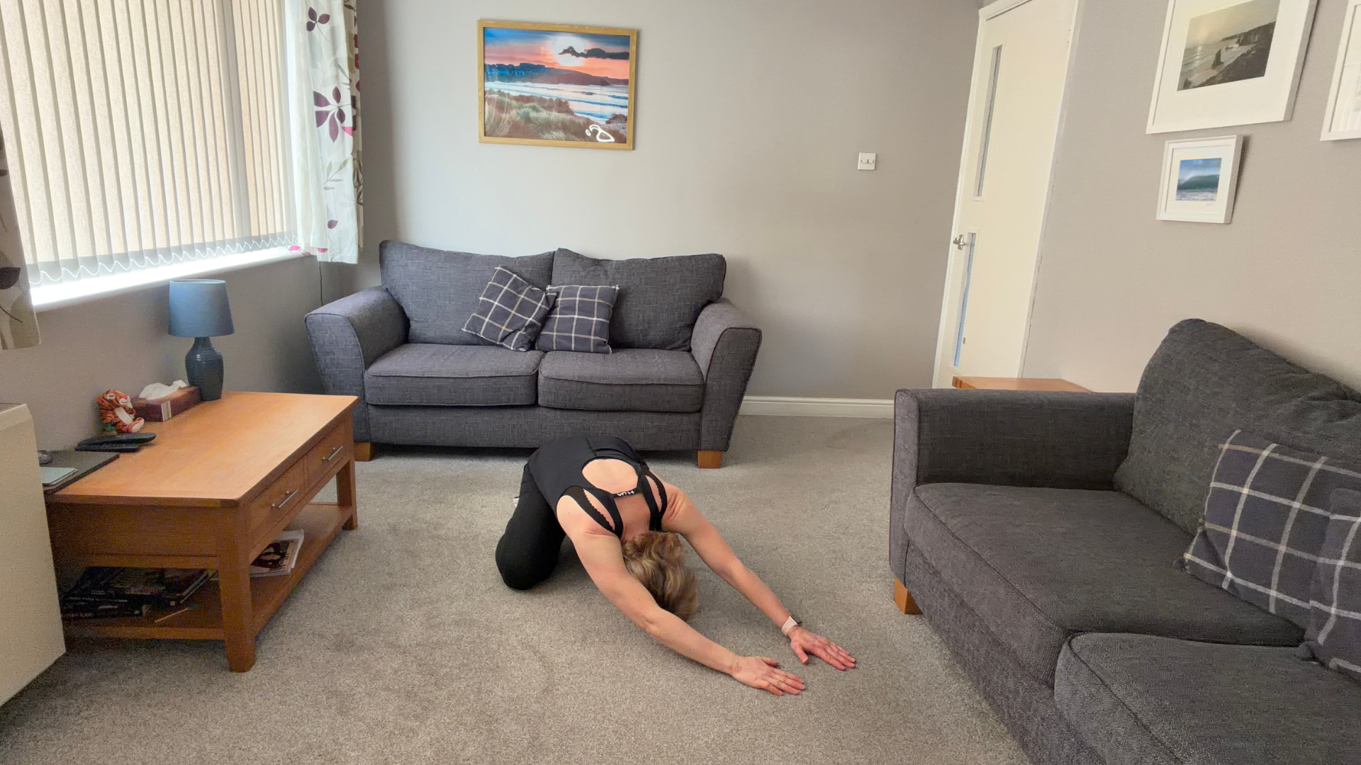 Personal trainer Becky Fuller performing stretching demonstrations in a living room