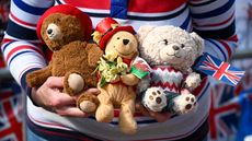 A person holds teddy bears commemorating the coronation of King Charles III. 