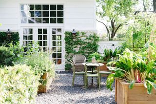 an outdoor dining area with a vegetable garden next to it