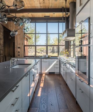 L-shaped kitchen with large windows and wood beams
