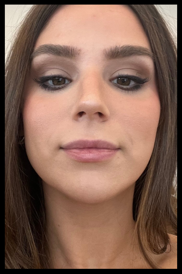 Girl with brown hair and eye makeup and no lip product on