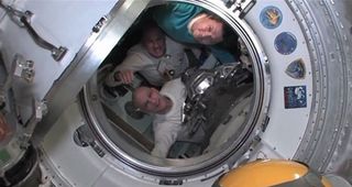 Expedition 31 commander Oleg Kononenko of Russia (top), Dutch astronaut Andrew Kuipers (center) and NASA astronaut Don Pettit bid farewell to their crewmates on the International Space Station just before shutting the hatches between their Soyuz and the station for a July 1, 2012, return to Earth.