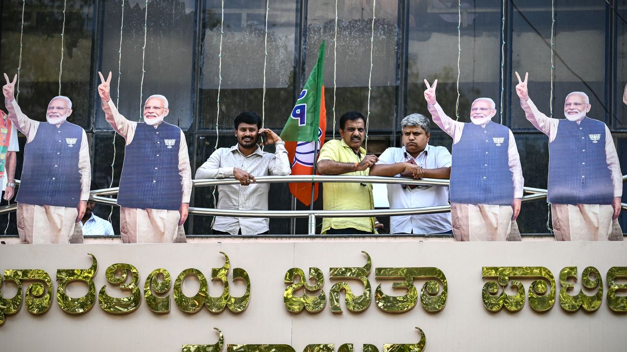 Supporters of Indian Prime Minister Narendra Modi take in 2024 election results