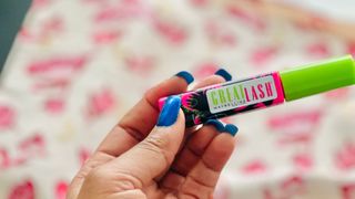 A person holding the pink and green Maybelline Great Mascara for the Maybelline Great Mascara review.