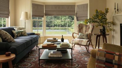 Heidi Caillier x Lulu and Georgia collection, including an antique-inspired pattern rug, aged wooden furniture, and ample floral upholstery, styled inside of a sunlit living room