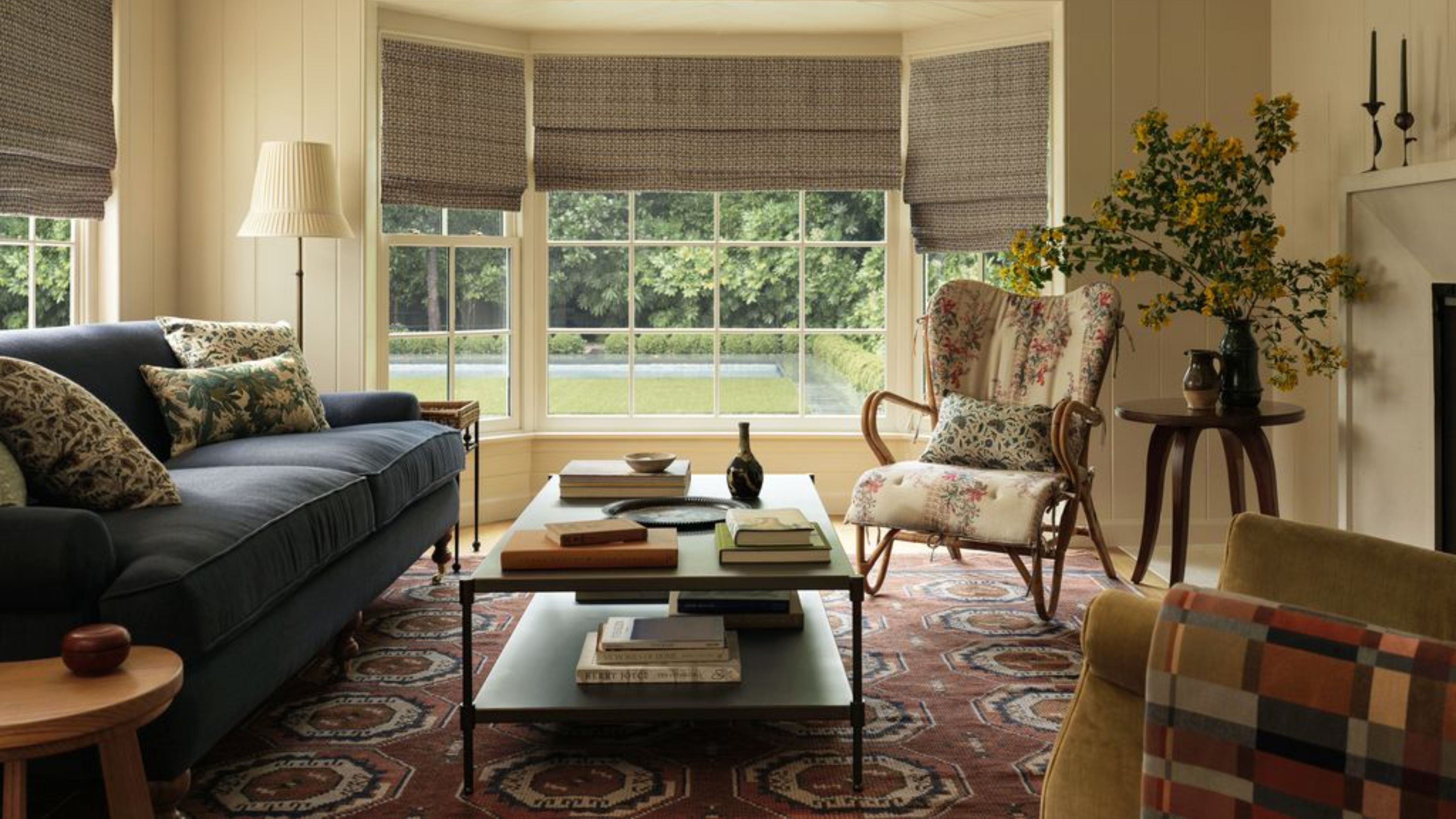 Heidi Caillier x Lulu and Georgia collection, including an antique-inspired pattern rug, aged wooden furniture, and ample floral upholstery, styled inside of a sunlit living room