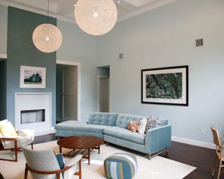 Living room with light blue velvet sofa, coffee table and two neutral armchairs