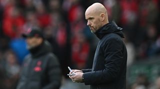 Manchester United manager Erik ten Hag makes notes during his side's 7-0 loss to Liverpool at Anfield in the Premier League in March 2023.