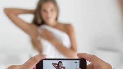Man taking photo of half naked woman