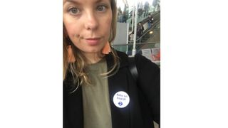 Woman looking into camera with baby on board badge