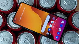 A Realme GT sat on top of some canned drinks