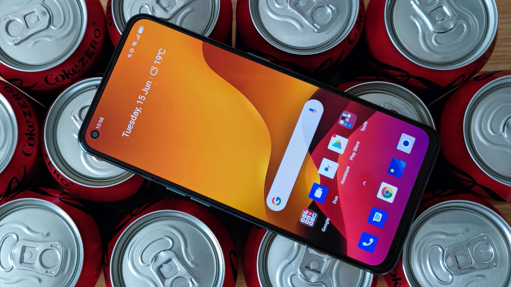 A Realme GT sat on top of some canned drinks