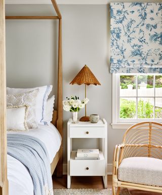neutral spring bedroom with blue floral blind and rattan furniture decor accents