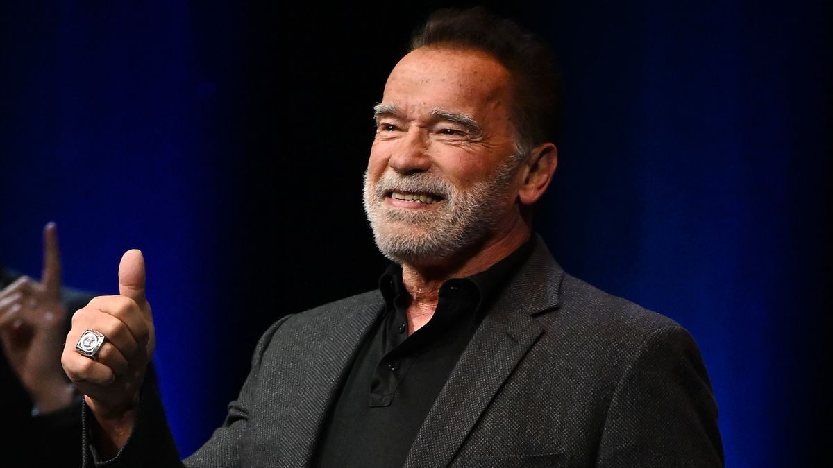 Arnold Schwarzenegger smiling and giving a thumbs up, he is arriving onstage at an Evening with Arnold Schwarzenegger presented by Fane at London Palladium on October 24, 2023