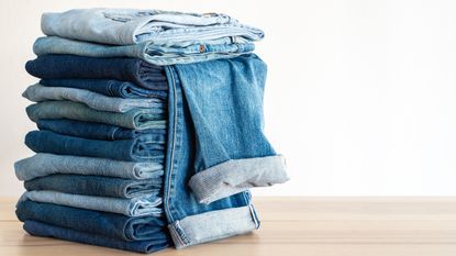 Multiple pairs of jeans folded in pile