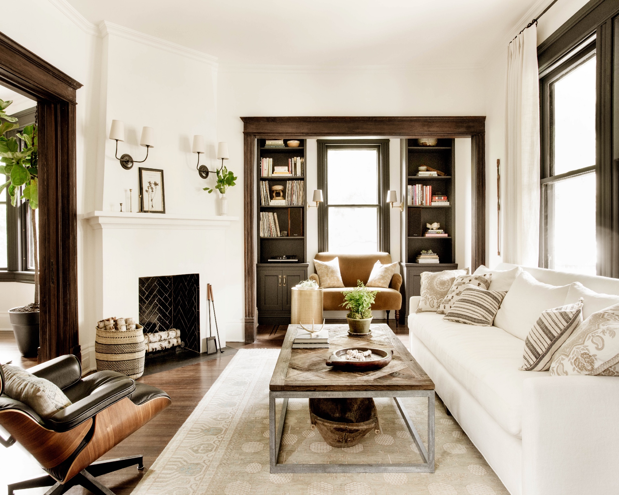 Corner fireplace in white living room with coffee table and area rug central to couches