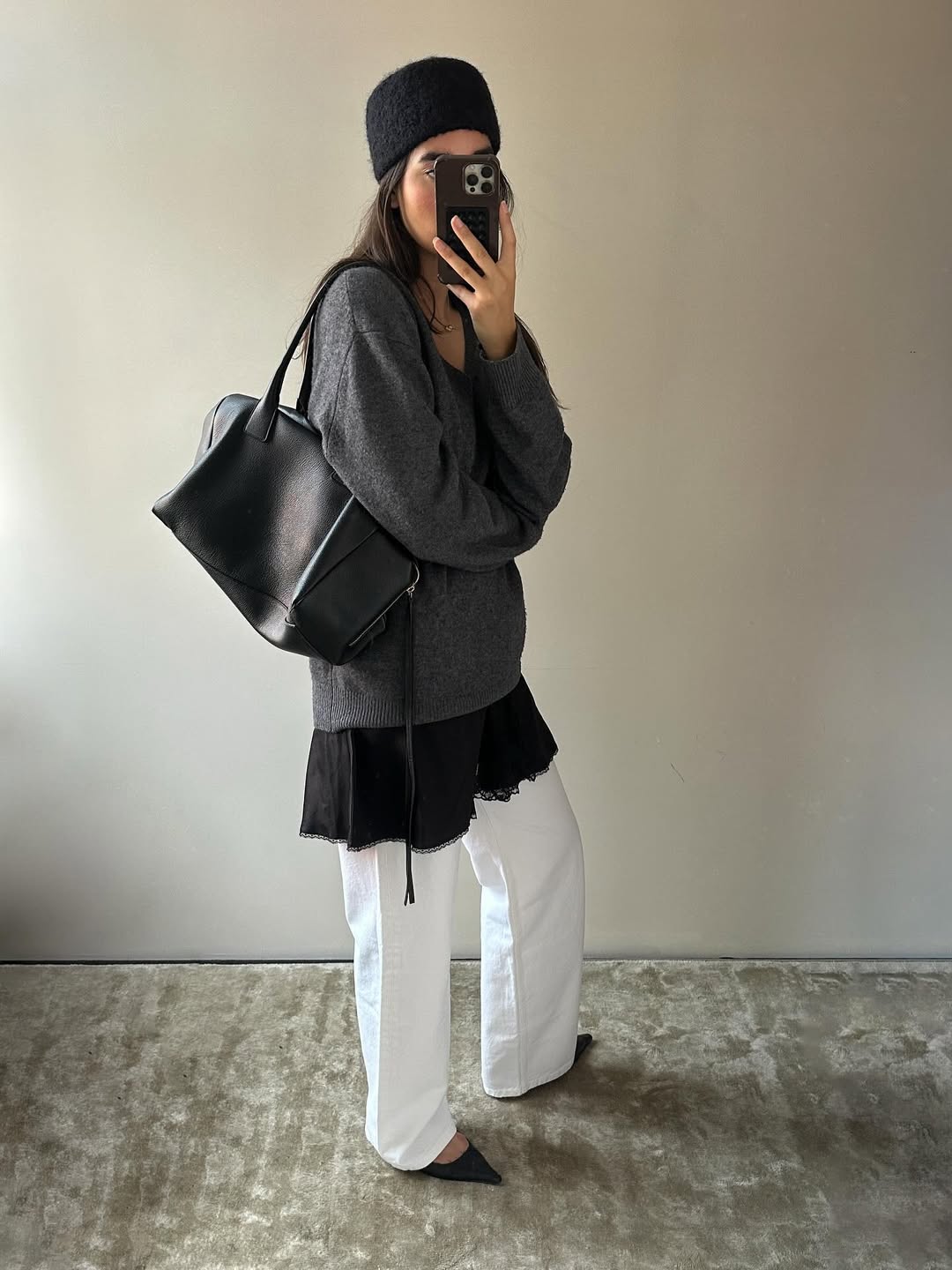 Influencer wearing a dress and jumper layered over white jeans