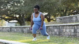 Woman doing weighted lunges in park