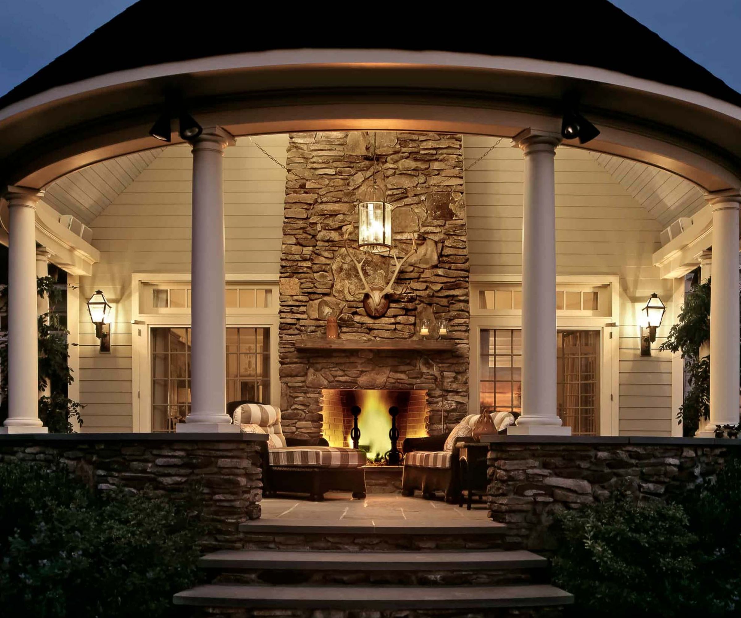 Porch with columns, built-in fireplace, striped loungers and steps